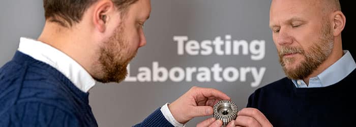 Two Silvent engineers outside the testing laboratory examining an air nozzle.